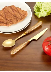 Ανοξείδωτα μαχαιροπήρουνα μαχαίρι μπριζόλας και κουτάλι λεπτομέρεια, χρυσό φινίρισμα.