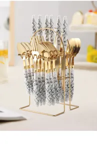 Ink pattern stainless steel tableware set with gold stand, fork, spoon and knife for dining.