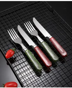 Set di posate in acciaio inox con manici glitterati, vista dettagliata di coltello e forchetta da tavola.