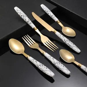Stainless steel flatware set with gold finish and ink splatter handle for home kitchen.