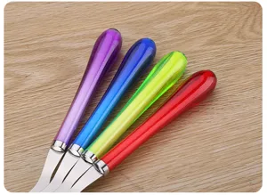 Detalle de juego de cubiertos de acero inoxidable, cuchillo y tenedor con mango transparente.