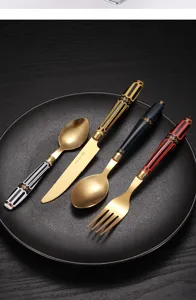 Dettaglio posate in acciaio, cucchiaio coltello forchetta dorati di lusso manico retro.
