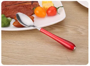 Cuchara de acero inoxidable con mango rojo, detalle de cubiertos, vajilla elegante para mesa.