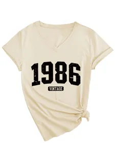 Dettaglio t-shirt beige collo a V manica corta con stampa vintage 1986 e orlo annodato.