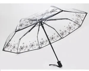 Ombrello pieghevole trasparente con stampa floreale nera, elegante e pratico per la pioggia.