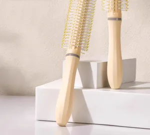 Detail view of round hair styling brushes in beige with white bristles for home salon use.