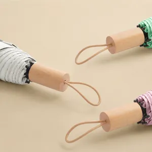 Paraguas plegable compacto de tres secciones con mango de madera real y correa de mano.