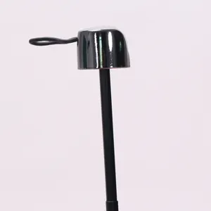 Close-up detail of a compact folding umbrella handle and cap with hanging loop, black gloss.