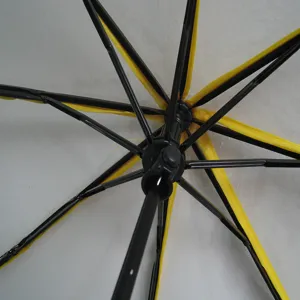 Transparent folding umbrella with black frame and yellow trim, bottom view of the sturdy structure.