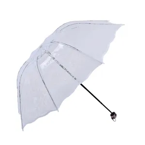 Clear folding umbrella with lace heart pattern, waterproof vinyl, stylish and portable design.