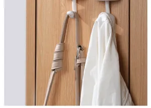 Vista dettagliata di gancio adesivo bianco su porta in legno per stoccaggio domestico.