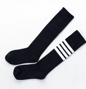 Detail view of black knee high socks featuring white stripes, soft cotton athletic style.