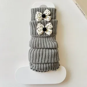 Calentadores de punto grises con lazos bonitos, calcetines de invierno acogedores de mujer