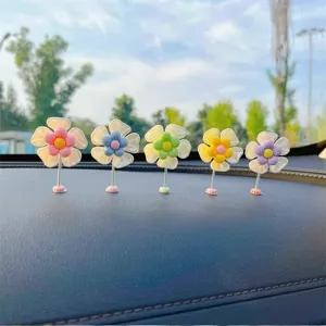 Joli ensemble d'ornements de fleurs secouant le tableau de bord de voiture, décor coloré.