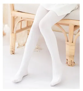 Detailed close-up view of children's white dance tights and soft socks in scenic setup.