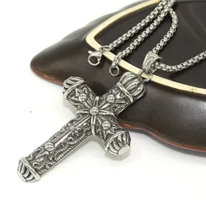 Detailed close-up of vintage punk style cross pendant necklace, intricate carved metal gothic design.