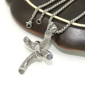 Stainless steel wood grain cross pendant necklace, detailed closeup of gothic vintage style jewelry.