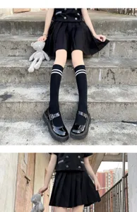 Close-up detail of classic black knee high socks with double white stripes, fashionable and comfortable style.