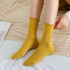 Detailed shot of yellow ribbed mid-calf socks with cute lettuce edge for women daily wear.