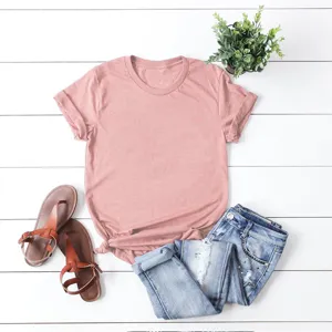 Vista dettagliata di una t-shirt rosa a maniche corte casual in flat lay con jeans e sandali.