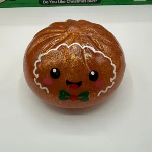 Close up of glitter brown Christmas bun squishy toy with cute face and bow, stress relief.