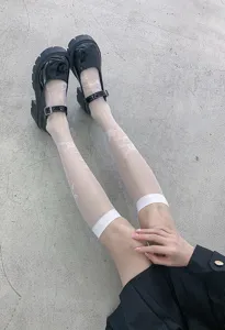 Sheer knee high socks with rose pattern paired with black platform Mary Jane shoes for women.