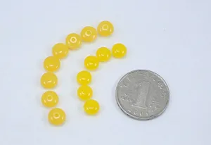 Primo piano dettagliato di perline distanziatrici in finta ambra gialla per accessori fai da te.