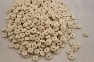 Perline distanziatrici bianco avorio nel dettaglio, ideali per gioielli e bracciali fai-da-te.
