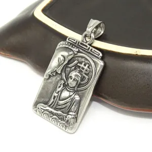 Vintage stainless steel religious Buddha pendant necklace closeup detail view, retro metal charm.