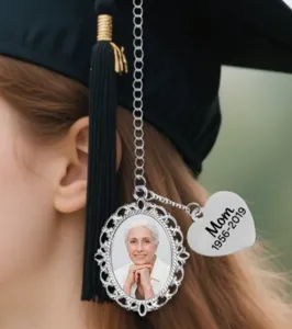 Detail shot of custom graduation cap tassel charm with photo frame and memorial heart tag.