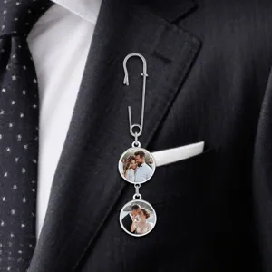 Close-up detail of custom photo brooch featuring silver safety pin and double picture charms.