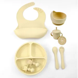 Complete silicone baby feeding set with suction bowl, divided plate, bib, cup, and spoon.