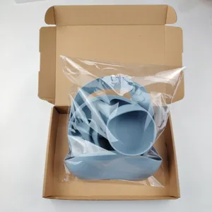 Silicone baby feeding set detail showing blue suction plate, bowl, bib, spoon and fork.