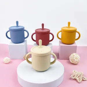 Silicone baby training cup with dual handles and lid, anti-scald toddler drinking water bottle.