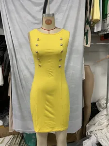 Λεπτομέρεια κίτρινου αμάνικου φορέματος bodycon, μεταλλικά κουμπιά, στενή κομψή γραμμή.