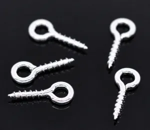 Gros plan detaille de vis a oeillet argentees, crochets metalliques pour bijoux et artisanat.