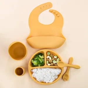 Silicone baby feeding set detail showing suction plate, bowl, bib, cup, fork and spoon.