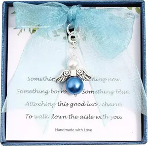 Bridal angel charm detail view with blue pearl and ribbon in gift box for wedding accessory