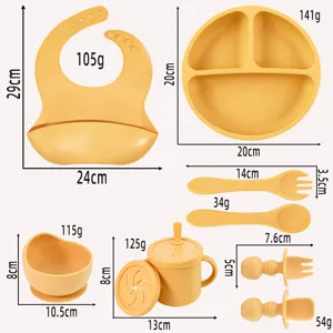 Silicone baby feeding set with divided plate, bowl, bib, cup, and spoons for toddlers.