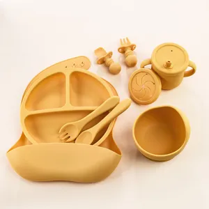 Set de repas en silicone pour bébé avec assiette compartimentée, bavoir, cuillère, tasse.