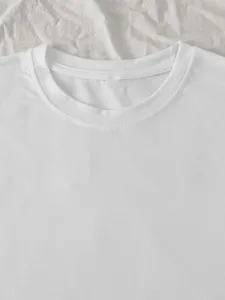 Close-up detail of white cotton crewneck t-shirt collar showing neat stitching and soft fabric.