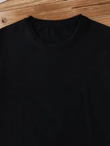 Close-up detail of classic solid black crewneck t-shirt fabric and neckline finish.