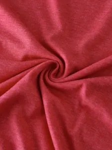 Red heather fabric detail shot, soft cotton blend material texture close-up apparel view.