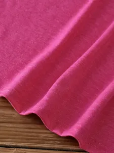 Detailed close-up shot of a pink solid color short sleeve t-shirt fabric and hem.