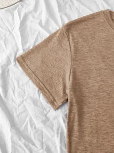 Close-up view of solid brown short sleeve t-shirt fabric, casual blank tee detail.