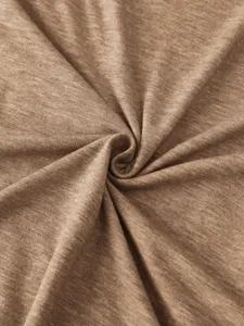 Close-up detail of soft brown knit fabric showing fine texture and spiral pattern.