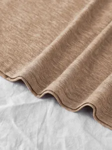 Close-up detail of soft khaki colored cotton t-shirt fabric texture and neat double stitching.