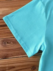 Detail shot of a solid light blue short sleeve t-shirt fabric and neat stitching.