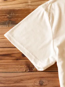 Detailed view of solid color short sleeve t-shirt sleeve, showing neat stitching and fine fabric.