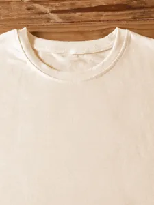 Close-up detail of solid color crew neck short sleeve blank t-shirt collar on wood.